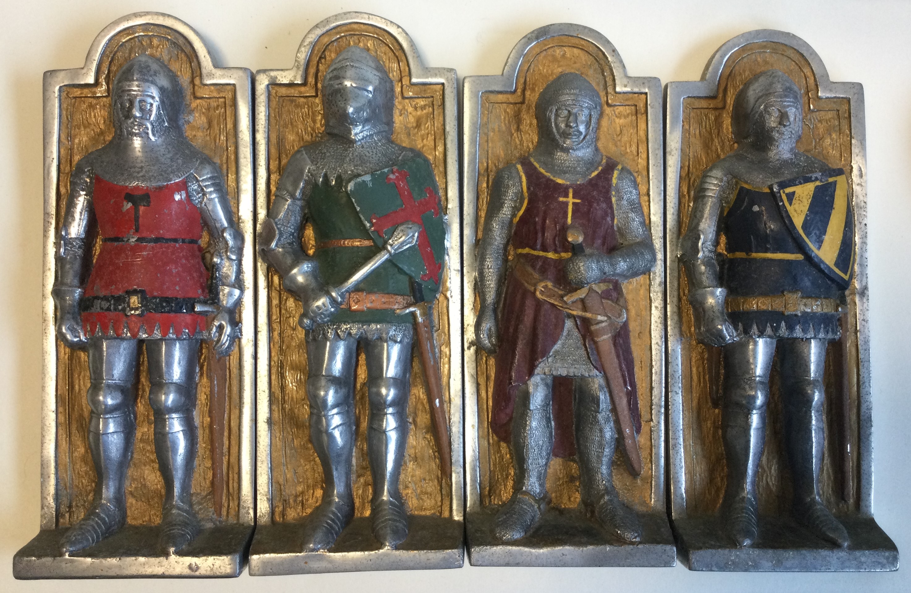 A set of four aluminium wall plaques depicting knights.