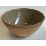 A small stoneware pottery bowl with green glaze to