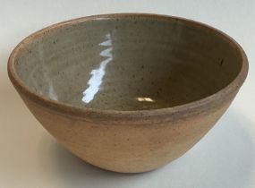 A small stoneware pottery bowl with green glaze to