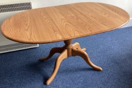 ERCOL: A small oval pedestal dining table.