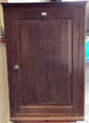 A large oak corner cupboard with painted shelves to interior.