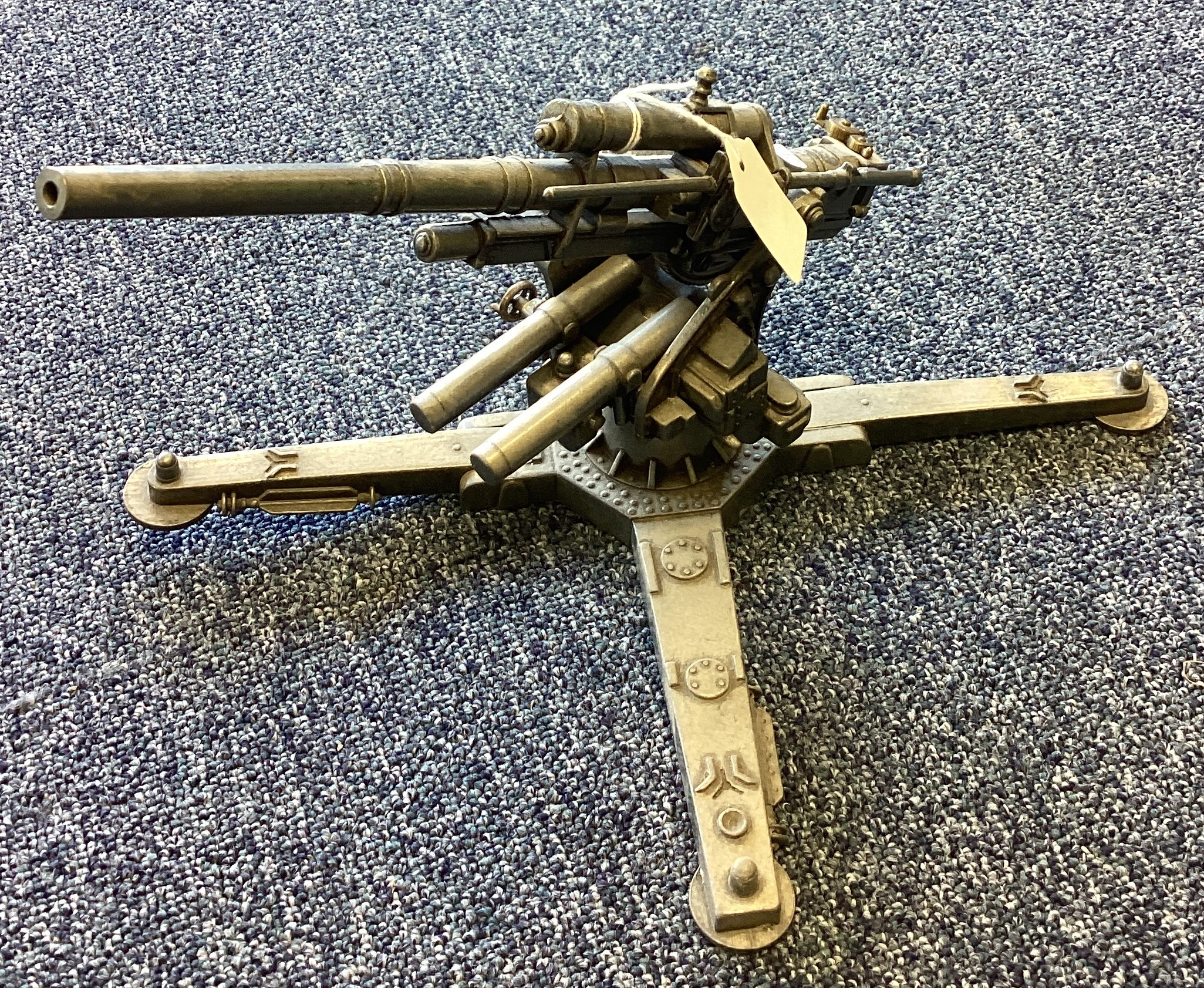 A heavy cast metal model of a machine gun on stand.