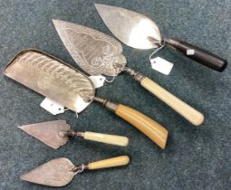 A large silver mounted and ebony trowel together with four plated examples.