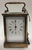 A small brass carriage clock with white enamelled dial.