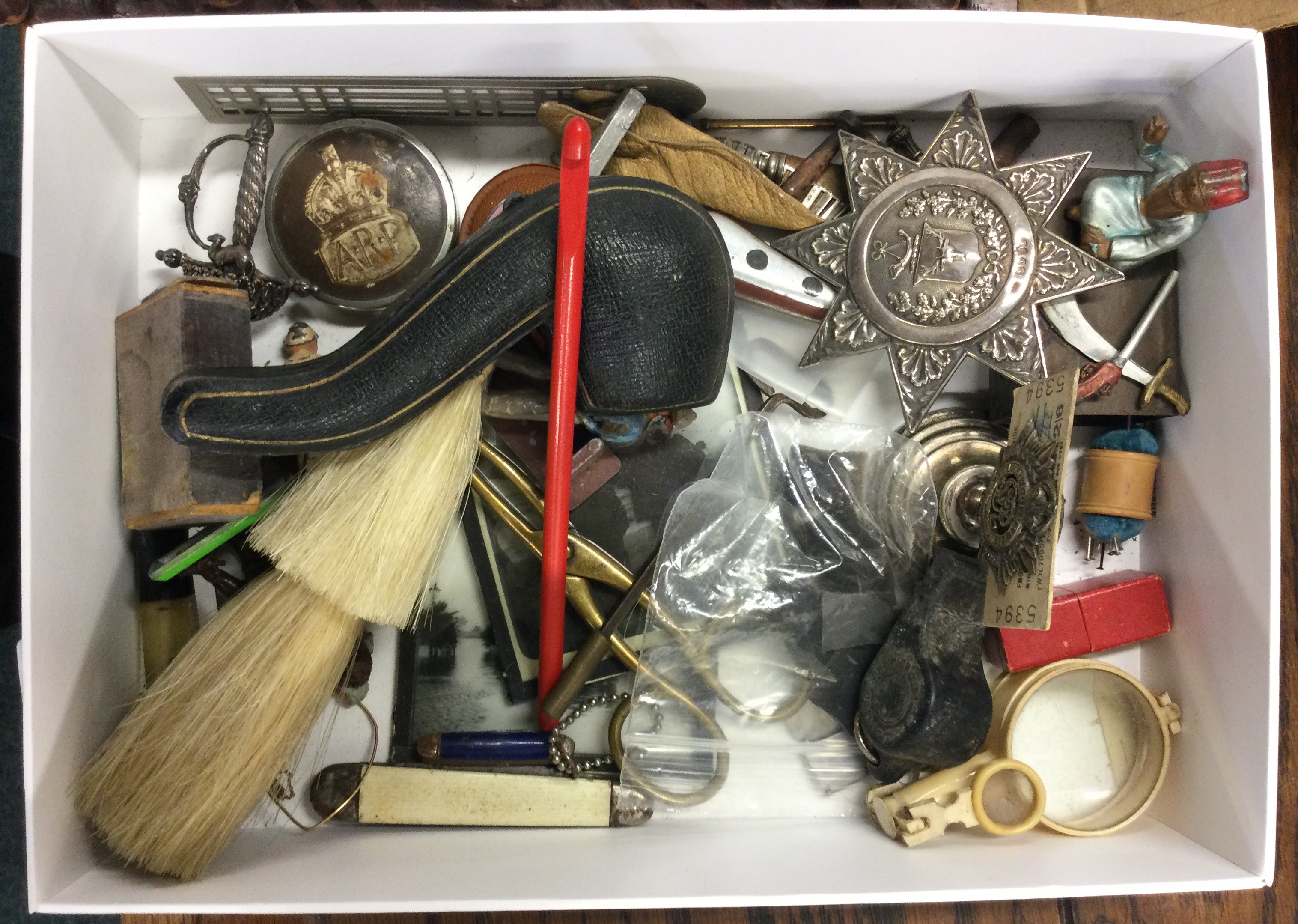 A box containing collectables, silver badge etc.