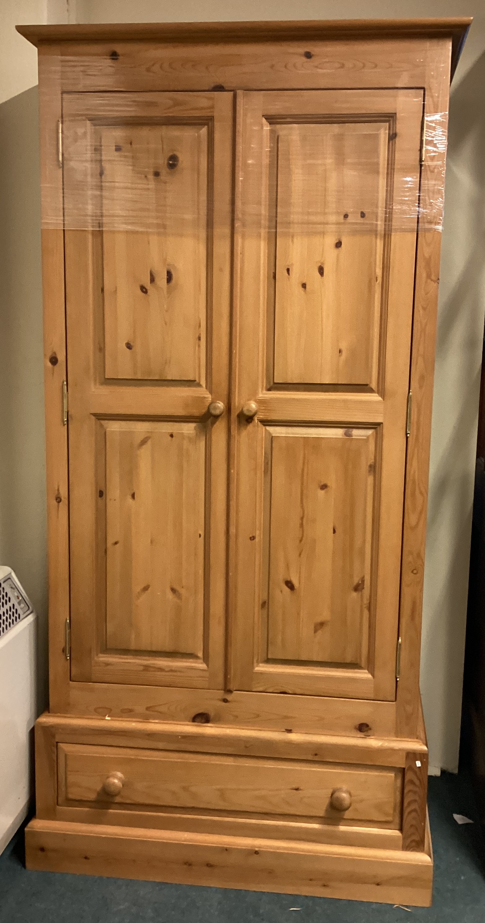 A stripped pine two door wardrobe.