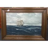 A wood framed and glazed picture of a galleon at sea.