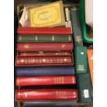 A collection of stamp albums and cigarette cards.