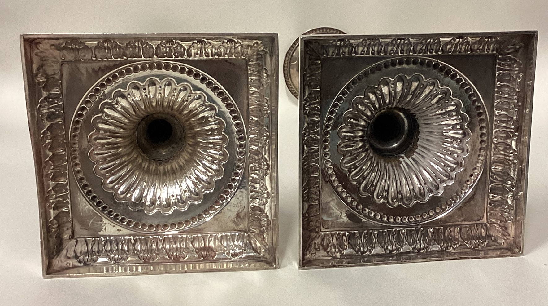 A pair of 18th Century Georgian cast silver candlesticks on square bases. - Image 4 of 4