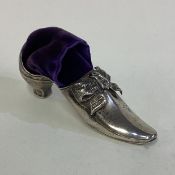 A Victorian silver pin cushion in the form of a shoe.