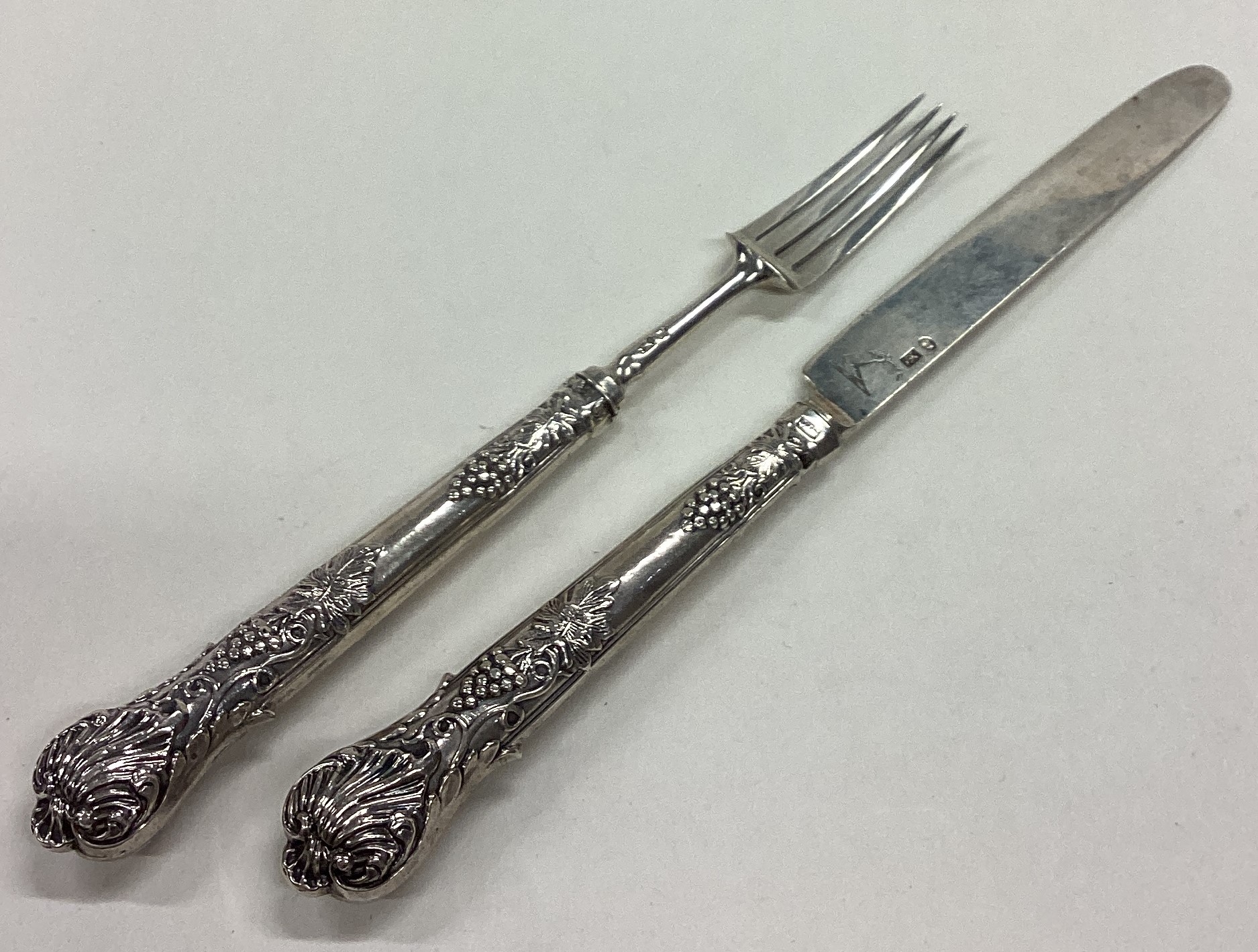 A crested William IV silver knife and fork set.