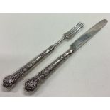 A crested William IV silver knife and fork set.