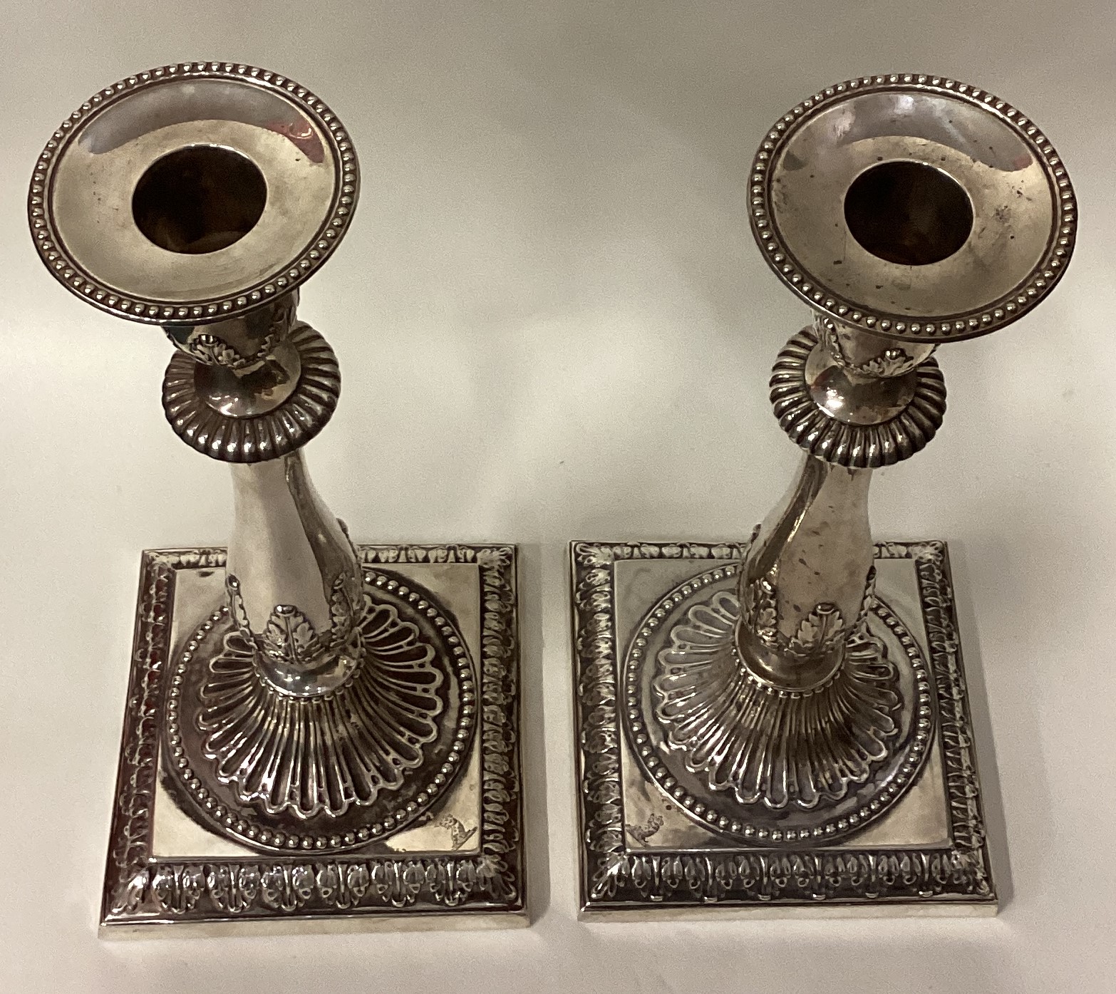A pair of 18th Century Georgian cast silver candlesticks on square bases. - Image 3 of 4