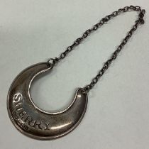 A crescent shaped silver wine label for 'Sherry'.