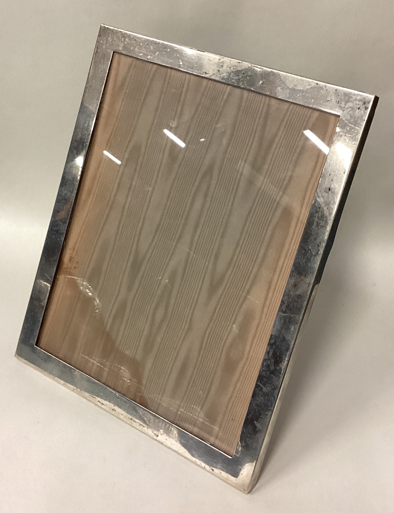 A large American silver picture frame with glass insert.