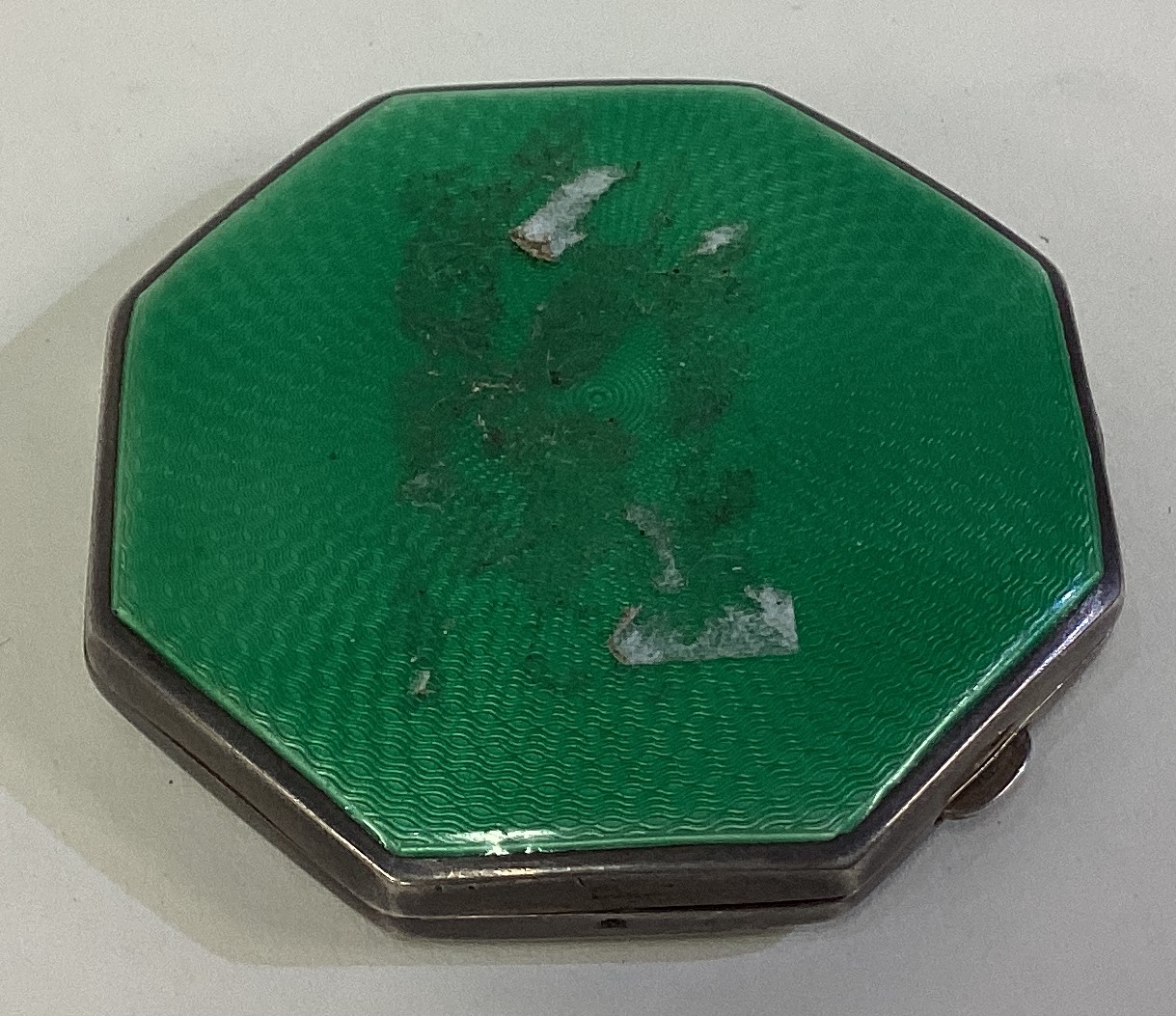 A silver and green enamelled compact.