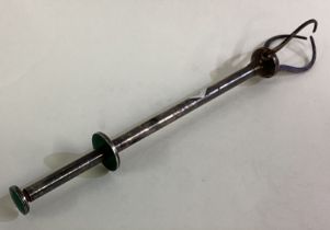 A large silver and green enamelled cocktail stick.