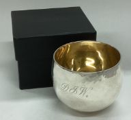 A cased Britannia silver tumbler cup with hammered decoration.