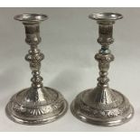 A pair of early Queen Anne cast silver candlesticks.