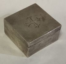 A square Edwardian silver pill box with cross decoration.