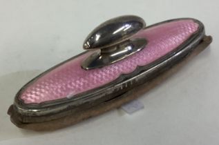 A silver and pink enamelled nail buffer.