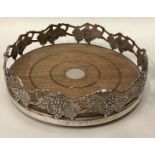 A large silver magnum coaster pierced with grapevine decoration.