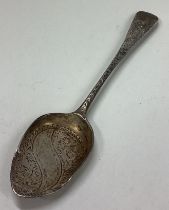 A Victorian silver jam spoon with engraved decoration.