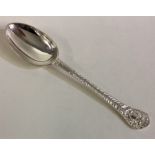 A silver spoon with chased lion decoration.