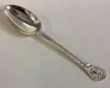 A silver spoon with chased lion decoration.