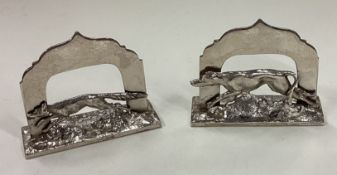 A pair of silver menu holders cast with fox and hound.