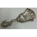 A Victorian cast silver caddy spoon with fluted bowl.