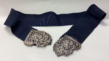 A heavy silver belt with pierced decoration.