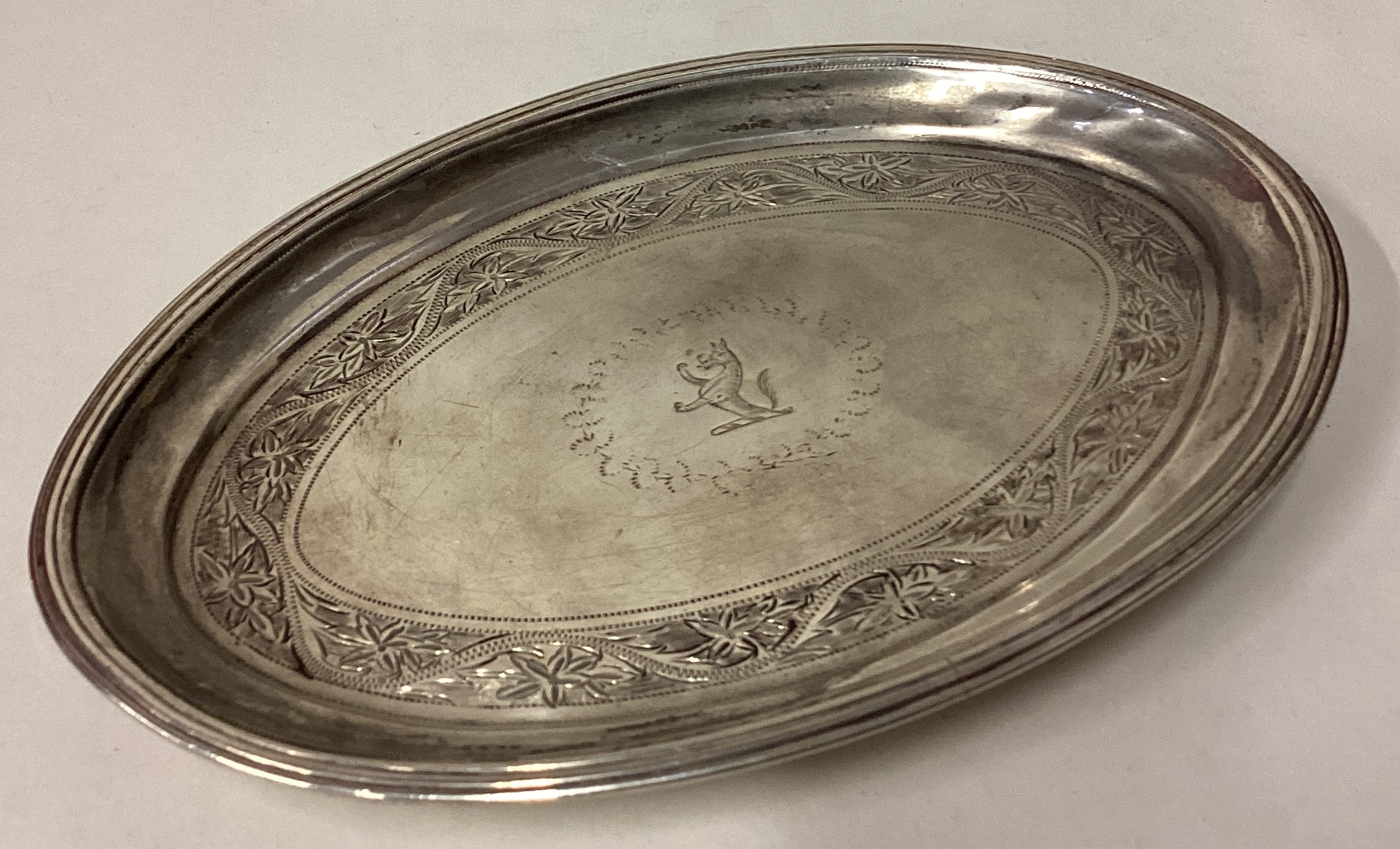 A heavy George III silver teapot stand with bright-cut decoration.
