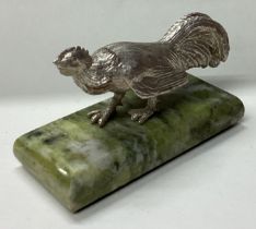 A heavy silver figure of a chicken on base.