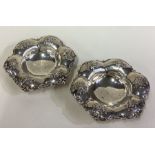 A pair of ornate American silver dishes on feet.