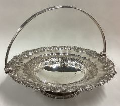 A large Georgian silver basket with shell border and chased decoration to interior and handle.
