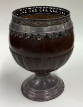 A large early 18th Century Provincial coconut cup with pierced floral border and coin to centre.
