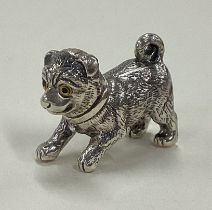 A Sterling silver figure of a dog with yellow eyes.