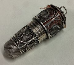 A rare Antique silver combination thimble / tape measure with filigree decoration.