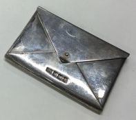 A silver pill box in the form of an envelope.