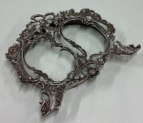 A small chased silver picture frame decorated with scrolls and flowers.