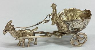 A silver figure of a man riding a goat bearing import marks.