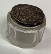 A chased silver box with lift-off cover decorated with cherubs.