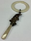 A silver rattle in the form of 'Punch'.