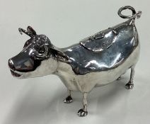 An early 20th Century Dutch silver cow creamer with hinged cover.