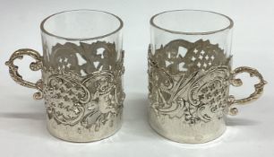 A pair of pierced Victorian silver vodka tots chased with cherubs bearing import marks.