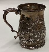 An 18th Century Georgian silver mug with chased decoration.