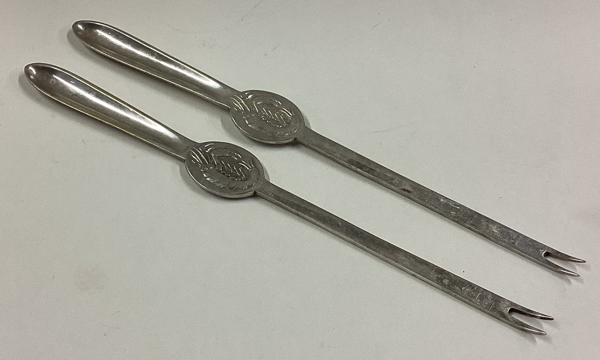 A pair of silver lobster picks.