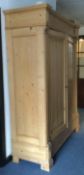 A large stripped pine wardrobe.