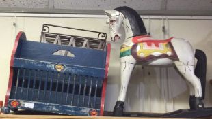 A painted rocking horse together with a magazine rack.